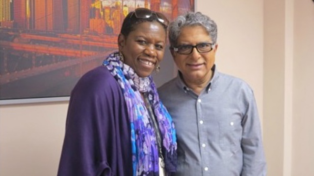 Deborah Mitchell, multimedia producer and Founder of Deborah Mitchell Media and Associates, smiling and standing with Deepak Chopra